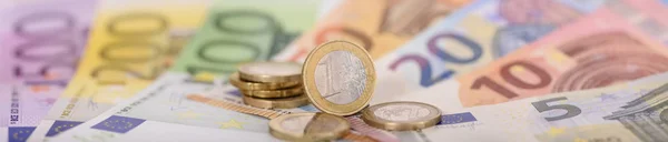 Många sedlar av europeisk valuta lägga under staplade mynt — Stockfoto