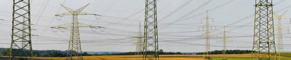 De nombreux pylônes haute tension pour le transport d'électricité à partir d'un pow — Photo