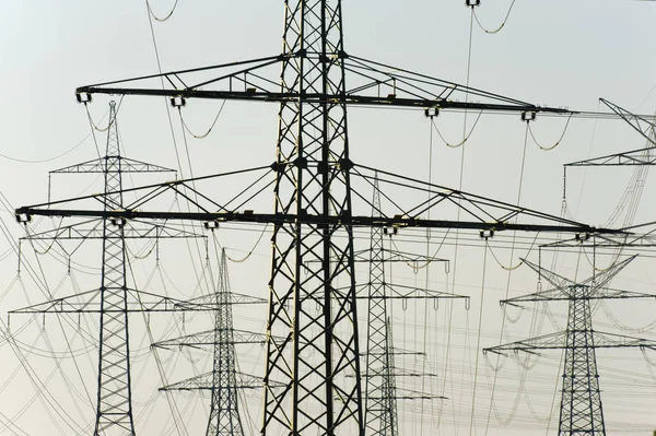 Many high-voltage pylons for transporting electricity from a pow — Stock Photo, Image