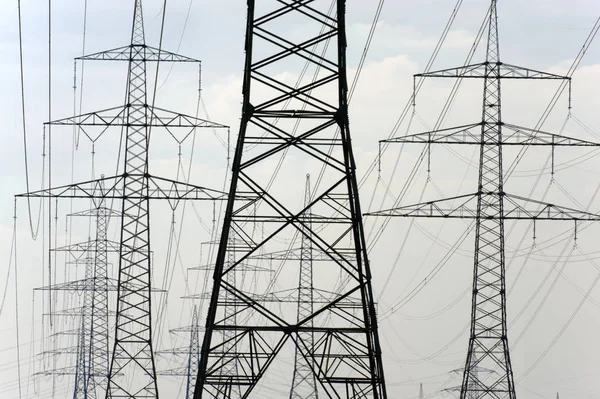 Muitos pilões de alta tensão para o transporte de eletricidade a partir de um pow — Fotografia de Stock