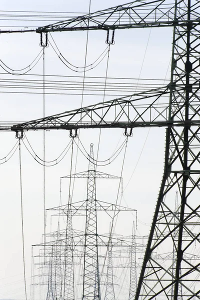 Mnoho stožárů vysokého napětí pro přepravu elektřiny z pow — Stock fotografie