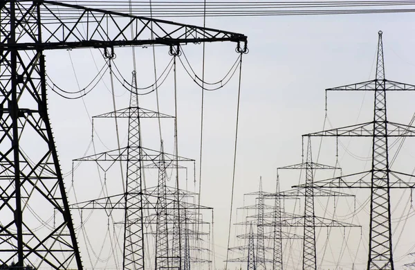 Many high-voltage pylons for transporting electricity from a pow — Stock Photo, Image