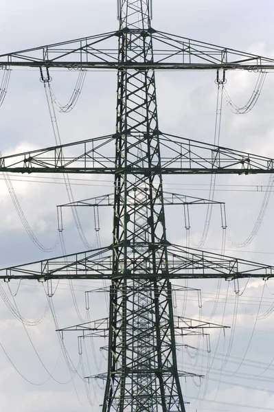 Vele hoogspanningsmasten voor het vervoer van elektriciteit uit een pow — Stockfoto