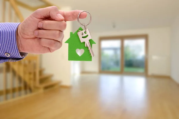 Llave de la casa en la mano del agente inmobiliario como oferta para el nuevo hogar — Foto de Stock