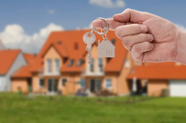 Hus nyckel på ringen i handen av fastighetsmäklare — Stockfoto