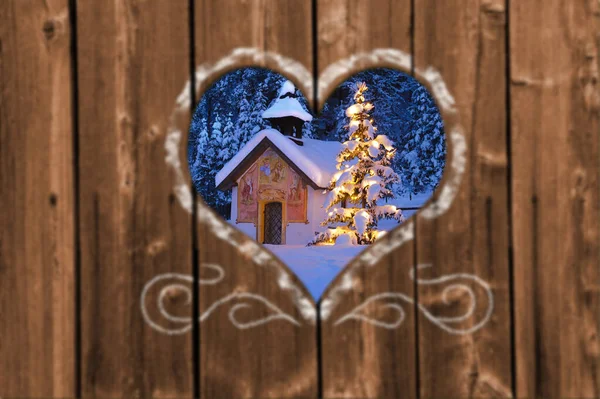 Pohled Skrz Vyřezávané Srdce Dřevěné Stěně Romantické Osvětlené Vánoční Kaple — Stock fotografie