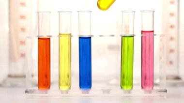 Kimya laboratuarındaki test tüplerinde renkli sıvı.