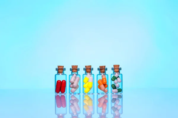 Five vials with colorful capsules — Stock Photo, Image