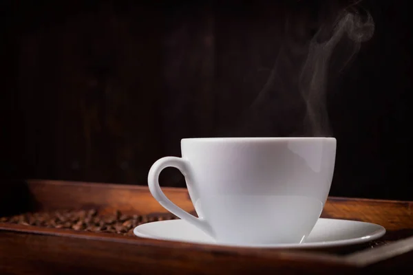 Чашка горячего кофе на тёмном фоне — стоковое фото