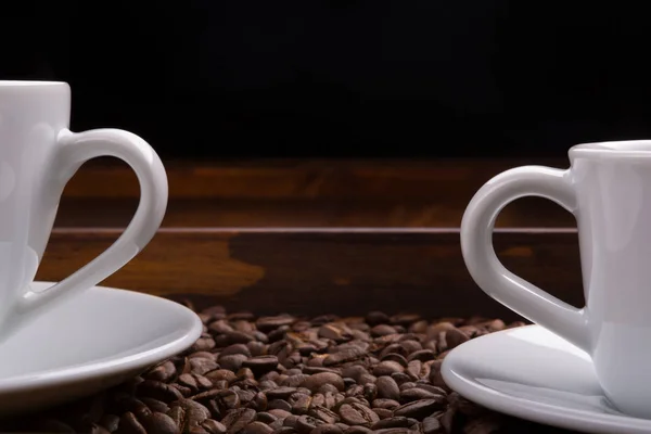 Две чашки с ручками на подносе, полном кофейных зерен — стоковое фото