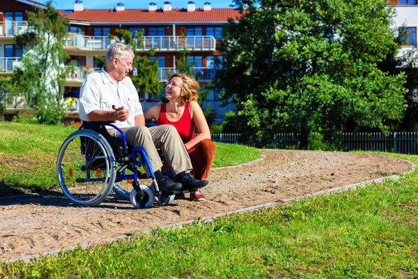 Man on wheelchair with young woman — Stock Photo, Image