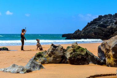 Praia da Adraga, Portekiz - 05 15 2016: kadın kayalık plaj