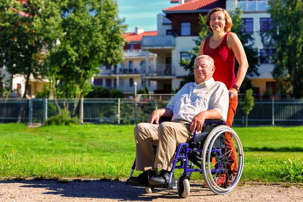 Man on wheelchair with young woman — Stock Photo, Image