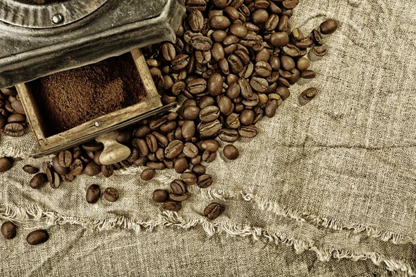 Macinacaffè e chicchi di caffè su tessuto di iuta — Foto Stock