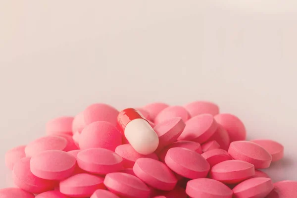 Pink pills and red capsule — Stock Photo, Image