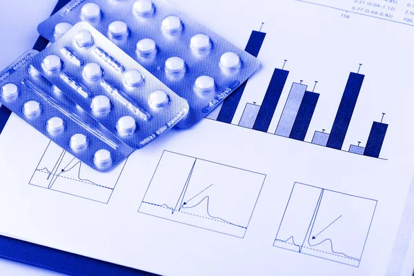 Pills in blisters and medical graphs — Stock Photo, Image