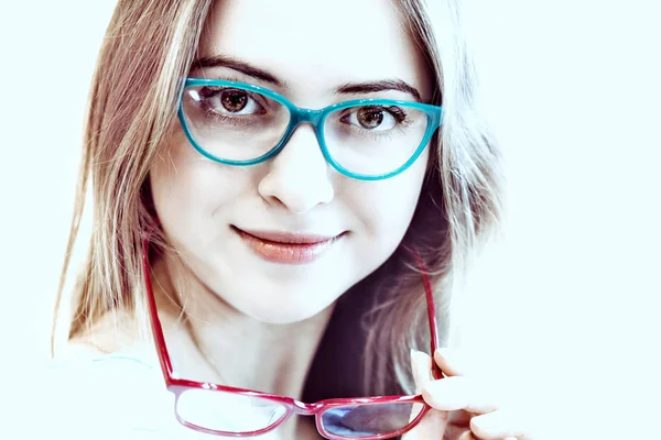 Mujer joven probándose diferentes pares de gafas — Foto de Stock