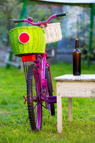 Różowy rower i butelka wina — Zdjęcie stockowe