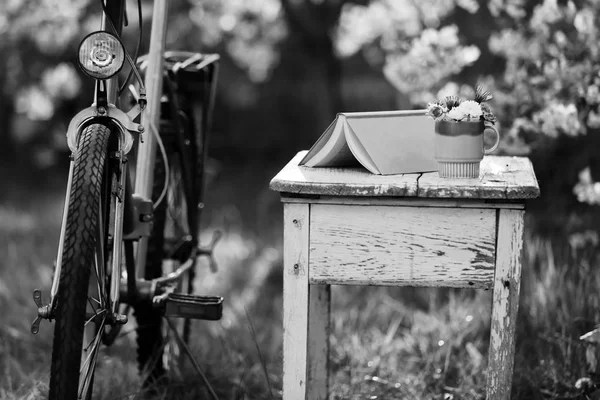 Велосипед и книга на старом столе — стоковое фото