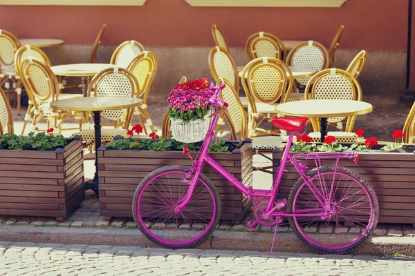 Розовый велосипед стоит на старой улице — стоковое фото