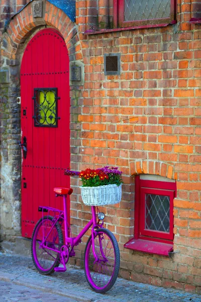 Bicicleta rosa em pé junto à parede — Fotografia de Stock