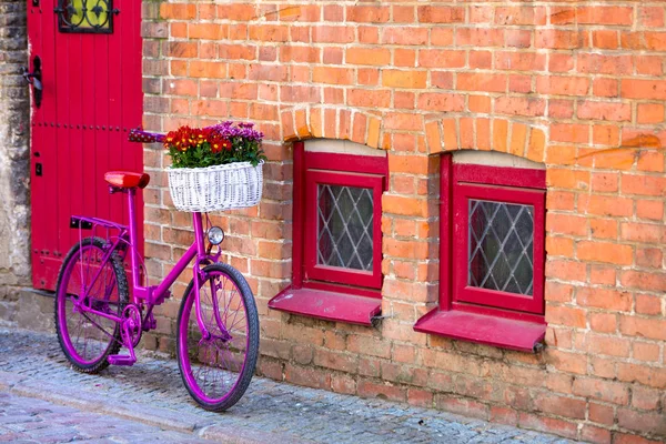 Różowy rower stoi przy ścianie — Zdjęcie stockowe