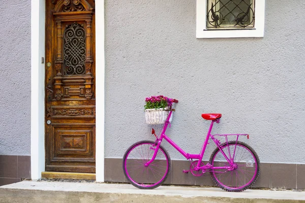 Bicicleta rosa em pé junto à parede — Fotografia de Stock