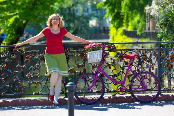 Frau mit rosa Fahrrad steht auf der Brücke der Liebe — Stockfoto
