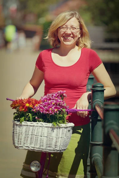 Sonriente mujer sosteniendo rosa bicicleta —  Fotos de Stock