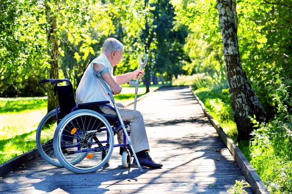 Yaşlı adam tekerlekli sandalye almaya çalışırken — Stok fotoğraf