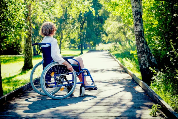 Ung vuxen kvinna på rullstolen i parken — Stockfoto