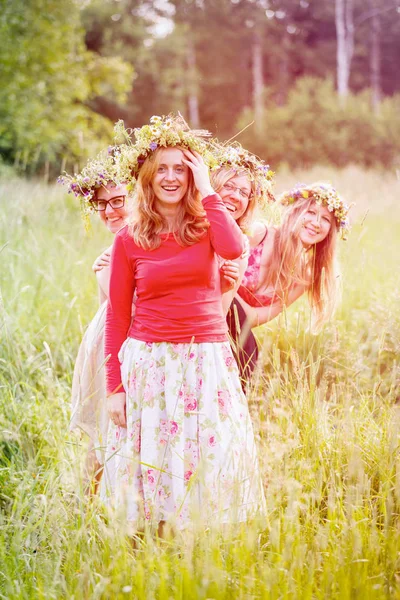 Cuatro mujeres con guirnaldas en un prado —  Fotos de Stock
