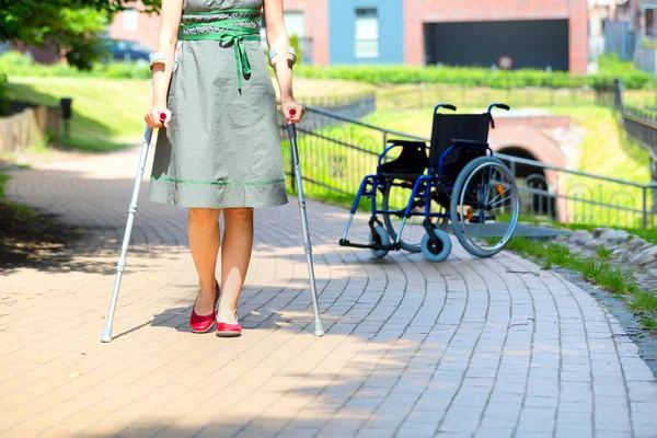 Mujer practicando caminar sobre muletas — Foto de Stock