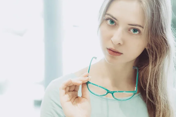 Retrato de mujer joven con gafas en la mano —  Fotos de Stock