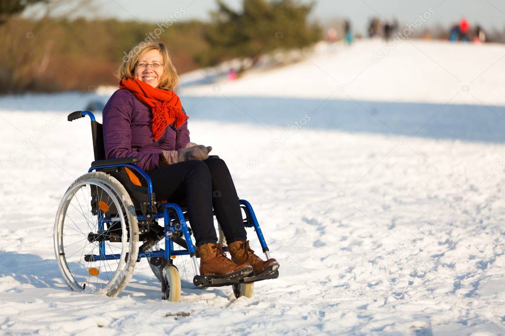 happy woman on wheelchair in the snow