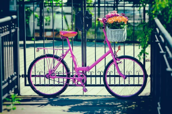 Vaaleanpunainen pyörä seisoo metalli este — kuvapankkivalokuva