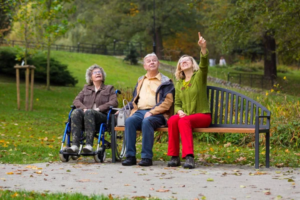Family in the park sitting on a bench — Stock Photo, Image