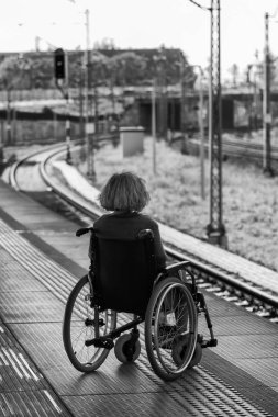 woman sitting on wheelchair on a platform 