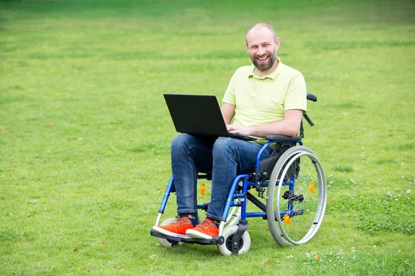 Man på rullstol arbetar på bärbar dator — Stockfoto