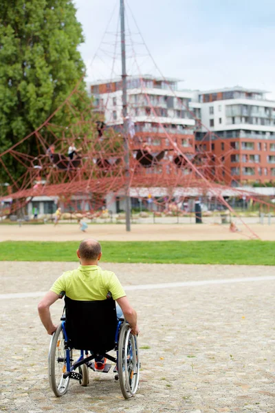 Man on wheelchair looking at net climber — Stockfoto