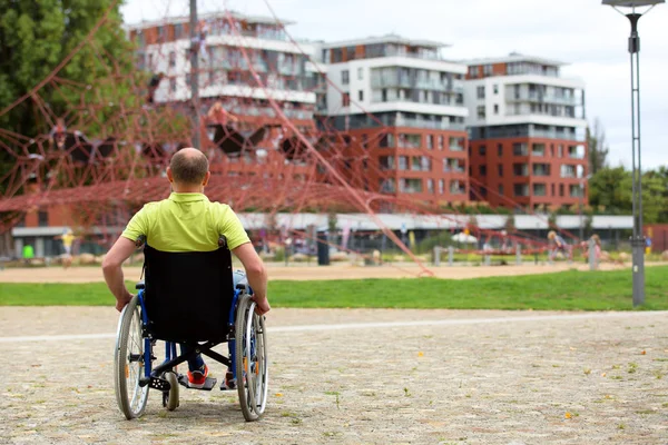 Άνθρωπος σε αναπηρική καρέκλα κοιτάζοντας ορειβάτης δίχτυ — Φωτογραφία Αρχείου
