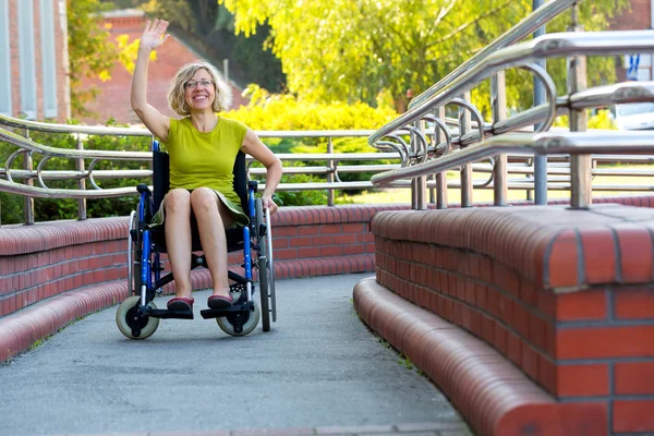 Woman on wheelchair waving with a hand — Stok fotoğraf