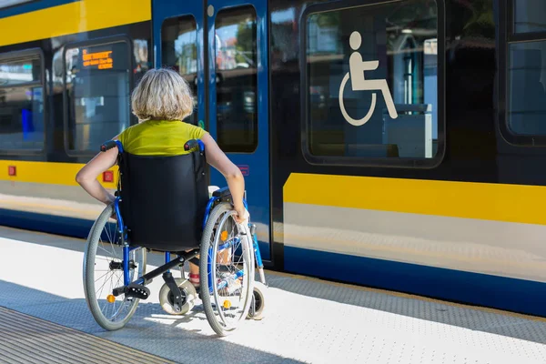 Woman sitting on wheelchair on a platform — Stok fotoğraf