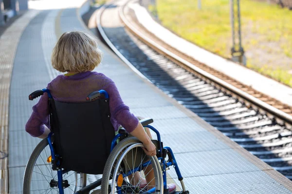 Woman sitting on wheelchair on a platform — Stockfoto