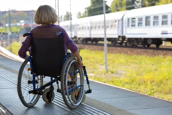 Woman sitting on wheelchair on a platform — Stok fotoğraf