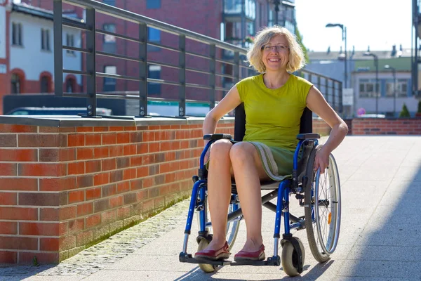Νεαρή ενήλικη γυναίκα σε αναπηρικό καροτσάκι στο δρόμο — Φωτογραφία Αρχείου