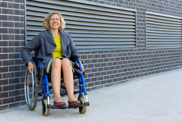 Νεαρή ενήλικη γυναίκα σε αναπηρικό καροτσάκι στο δρόμο — Φωτογραφία Αρχείου