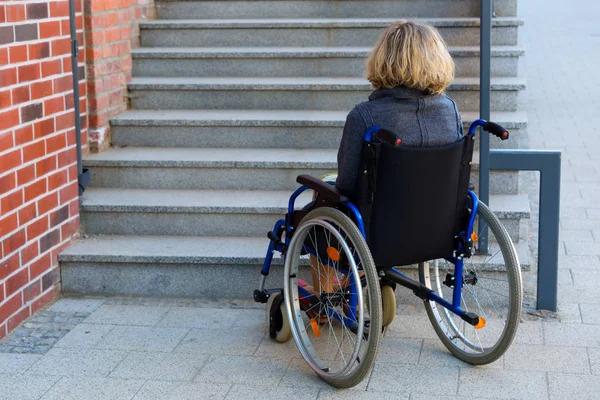 Kobieta na wózku inwalidzkim i schody — Zdjęcie stockowe