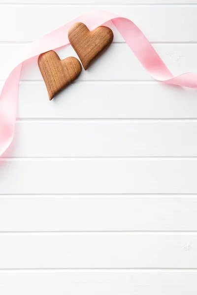 Two wooden hearts with pink ribbon. — Stock Photo, Image