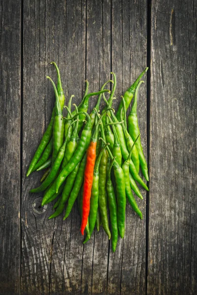 Pimentos verdes e uma pimenta vermelha . — Fotografia de Stock